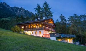 a large house on top of a hill at night at Landhaus Alpbach in Alpbach