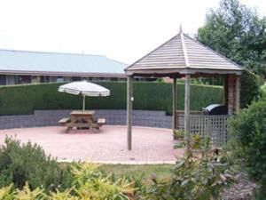 an outdoor area with a picnic table and umbrella at Kentish Hills Retreat in Sheffield