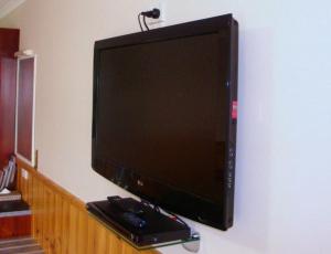 a flat screen tv sitting on top of a wooden stand at Kentish Hills Retreat in Sheffield