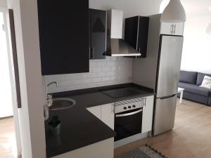 cocina con armarios blancos y negros y nevera en El Lomo, en Santa Cruz de la Palma