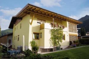 a yellow house with a table in front of it at Haus Rainer in Innsbruck