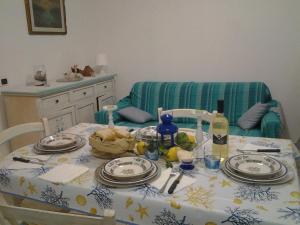 mesa de comedor con mantel azul y blanco en Casa Asia Residence Barrettini, en La Maddalena