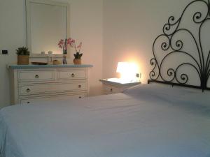 Un dormitorio con una cama con una cómoda y un espejo. en Casa Asia Residence Barrettini, en La Maddalena