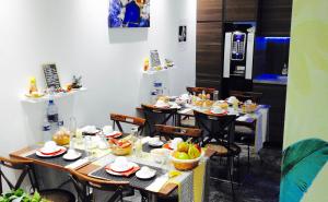 un comedor con mesas y sillas con comida. en Massilia hôtel, en Marsella