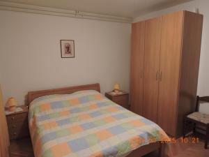 マリ・ロシニにあるApartments Ivankaのベッドと木製のキャビネットのある寝室