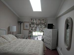 1 dormitorio con cama y ventana en Inn At The Park - The Cottage, en Cape May