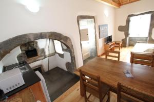 une salle à manger avec une table et un four à pizza dans l'établissement Casa Branca da Chaminé, à Cinco Ribeiras
