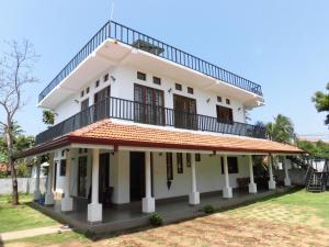 a white house with a balcony on top of it at Pick & Go White House in Negombo