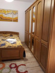 a small bedroom with a bed and a cabinet at Casa Oprea in Sinaia
