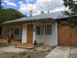 a small white house with a porch and a door at Casa Oprea in Sinaia