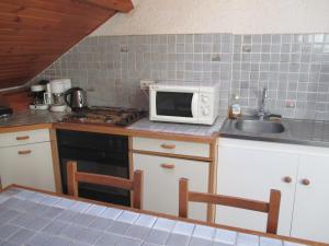 a kitchen with a microwave and a sink at La cle des champs in Murol