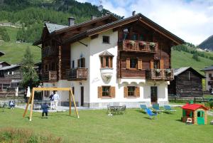 a house with a playground in front of it at Baita La Cometa in Livigno