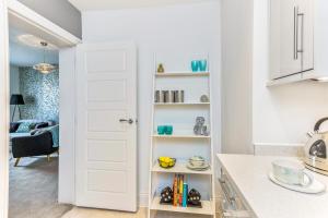 a kitchen with a door leading into a room at 3, Gainsborough House in Cheltenham