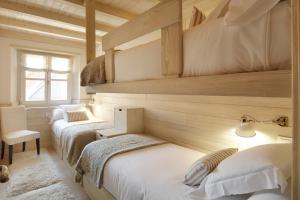 2 letti in una camera con pareti in legno di Val de Ruda Luxe 51 by FeelFree Rentals a Baqueira-Beret