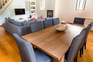 een eetkamer met een houten tafel en stoelen bij Casa da Oliveira in Porto