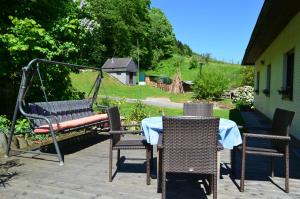 un patio con mesa, sillas y un columpio en Haus Donaublick en Engelhartszell