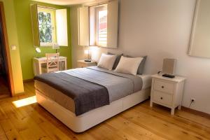 een slaapkamer met een bed met 2 tafels en een raam bij Casa da Oliveira in Porto