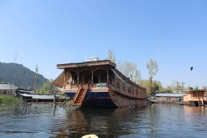 a boat is docked in the water on a river at House Boat New Lucifer in Srinagar