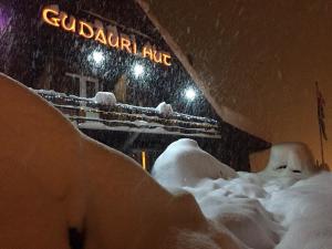 a snow covered parking lot with a train on it at Gudauri Hut Hotel in Gudauri