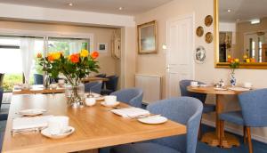 jadalnia ze stołem i niebieskimi krzesłami w obiekcie Sunny Brae Bed & Breakfast w mieście Nairn