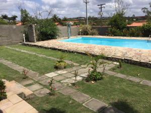 una piscina en un patio con plantas en el césped en Chacara em Gravata, en Gravatá