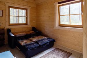 a small room with a bed in a log cabin at Domizil Katharina in Borkwalde