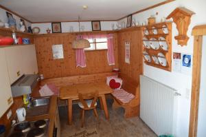 
a small kitchen with a wooden table and chairs at Haus Donaublick in Engelhartszell
