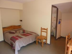 ブリッド・レ・バンにあるレジデンス ラ ロシュタイエのベッドルーム1室(ベッド1台、椅子付)
