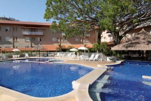 una gran piscina con sillas y sombrillas en Hotel Mantovani en Águas de Lindóia