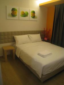 1 dormitorio con 1 cama con 2 sonrisas en la pared en GM City Hotel, en Klang