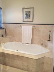 y baño con bañera grande y toalla. en Roman Retreat, en Ciudad del Cabo 10 fotos más