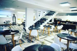 a restaurant with tables and white chairs and stairs at Residenza RoMa in Tropea