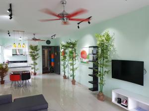 a living room with potted plants and a flat screen tv at Garden Apartment at Zenith in Petaling Jaya