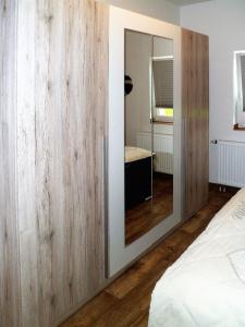 ein Schlafzimmer mit einer großen Holzwand und einem Spiegel in der Unterkunft Ferienwohnung Anke - Apartment 3a in Heinsberg
