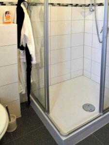 a shower with a glass door in a bathroom at Ferienwohnung Anke - Apartment 3a in Heinsberg