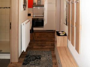 eine kleine Küche mit Holzböden und weißen Schränken in der Unterkunft Ferienwohnung Anke - Apartment 3a in Heinsberg