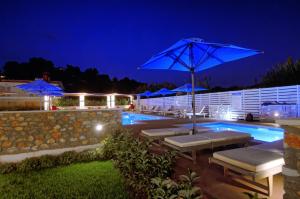 a pool with umbrellas and lounge chairs next to a pool at Hotel Korali in Troulos