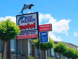 a group of signs in front of a building at Blue Dolphin Motel in Timaru