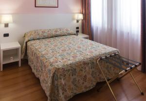 a bedroom with a bed with a floral bedspread at Hotel Pico in Mirandola
