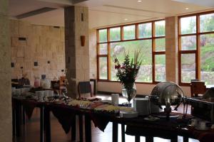 um quarto grande com uma mesa longa com pratos e flores em Taypikala Deluxe Valle Sagrado em Urubamba