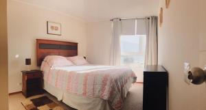 a bedroom with a bed and a window at La mejor vista de Papudo in Papudo