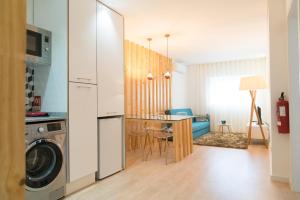 a kitchen and living room with a washer and dryer at Bracara Guest House "D. Pedro V" in Braga