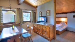 a bedroom with a bed and a desk with a television at Appartements Kohlereck in Sankt Anton am Arlberg
