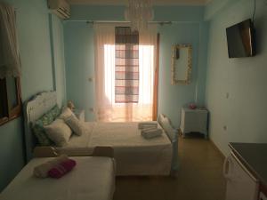 een slaapkamer met 2 bedden en een raam bij Aethrio Guesthouse in Souvala