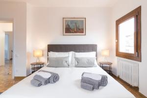 um quarto com uma grande cama branca e 2 candeeiros em Residence on the Canal em Veneza