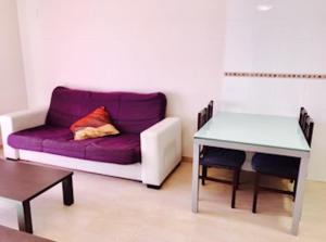 ペニスコラにあるÁticos Boutique Peñíscolaの紫色のソファとテーブル付きのリビングルーム