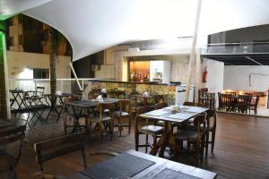 a restaurant with tables and chairs in a room at Bevile Hotel in Cataguases