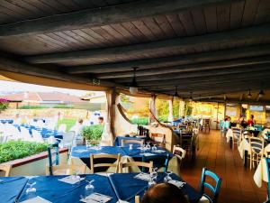 a restaurant with blue tables and chairs and people at Hotel Porto Puddu - Il Nido dei Gabbiani in Porto Pollo