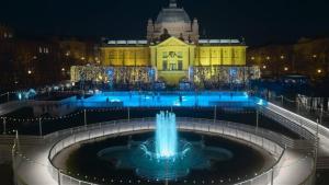 a fountain in front of a building at night at Apartments Zagreb Center in Zagreb