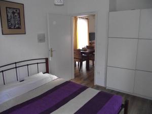 - une chambre avec un lit et une salle à manger dans l'établissement Apartments Dobrinj, à Dobrinj